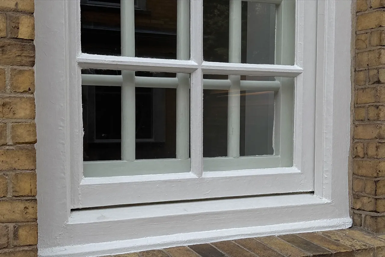 A painted timber sash window on a period brick house