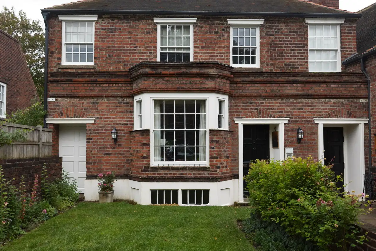 The front of a Victorian brick terrace with white sash windows